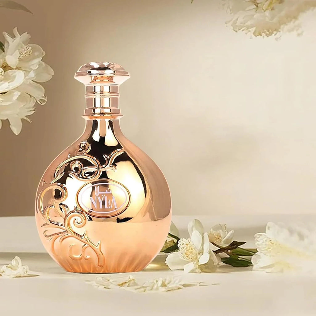 Nyla Vani-Elle perfume bottle surrounded by white flowers on a soft cream background